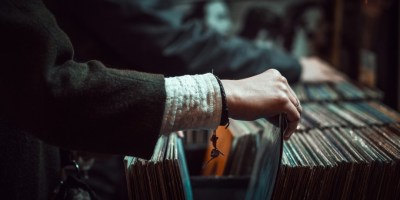 person going through record store shelves to illustrate leaving home by michael goth