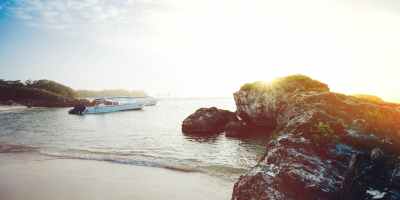 motorboat on seashore near rocks