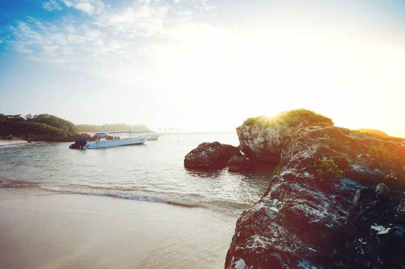 motorboat on seashore near rocks