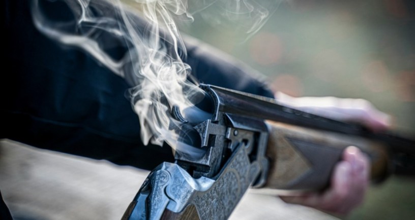 Man holding smoking rifle. Photo by Paul Einerhand on Unsplash