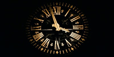 Black clock with gold hands to illustrate "Death Becomes Her" by Leah Fisher