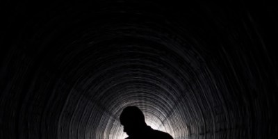 silhouette of man standing in tunnel