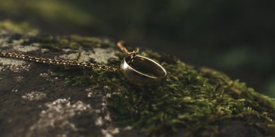 One Ring from The Lord of the Rings laying on dark stone. Photo Credit: Алексей Вечерин/Pexels https://www.pexels.com/photo/ring-pendant-on-rock-with-moss-9551089/