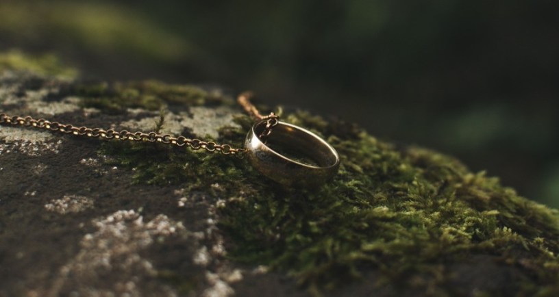 One Ring from The Lord of the Rings laying on dark stone. Photo Credit: Алексей Вечерин/Pexels https://www.pexels.com/photo/ring-pendant-on-rock-with-moss-9551089/