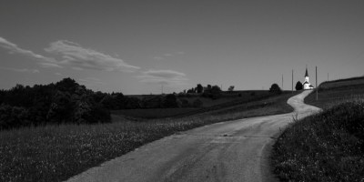 Road leading to white church building https://www.pexels.com/photo/tranquil-rural-road-leading-to-a-remote-church-34678668/